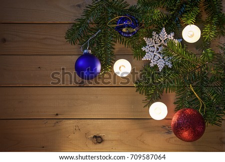 Christmas themed background with candles,decorations and some fir branches. Picture is warm matt tones