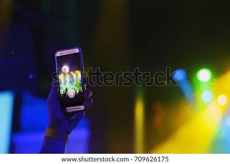 silhouette of hands with a smartphone in the background singing rap artists in the spotlight, the shadow hand fans