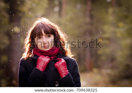 young beautiful girl walking in autumn forest in the sun rejoices first snow