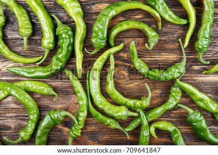 a lot of green chili peppers on a vintage wooden background