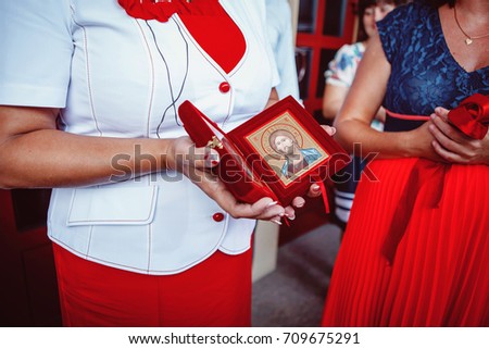 A woman holding Orthodox con in her hands