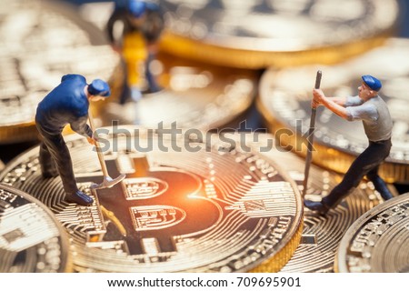 macro miner figures working on group of bitcoins. virtual cryptocurrency mining concept Royalty-Free Stock Photo #709695901