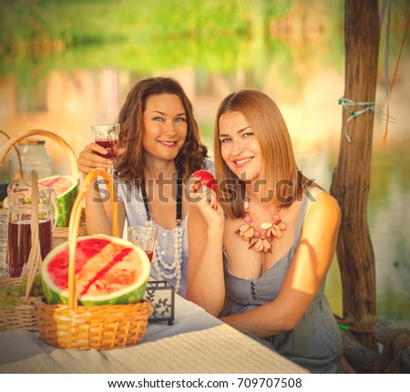 Two beautiful women on a picnic by the lake. instagram image filter retro style