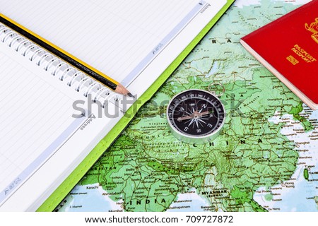 Travel concept image.Compass, note book and passport on map background.Selective focus.