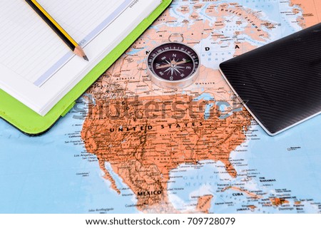 Travel concept image.Compass, note book and smartphone on map background.Selective focus.