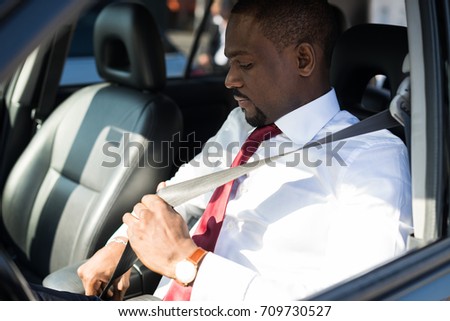 Man fastening the seatbelt in his car Royalty-Free Stock Photo #709730527