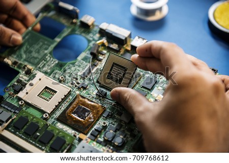 Closeup of hands with computer main board microprocessor electronics parts Royalty-Free Stock Photo #709768612