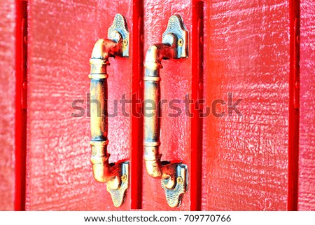 old red wooden entrance door with antique door handle                               