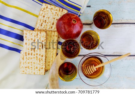 Beautiful green, yellow and red apples, pomegranates and lemons with honey on a wooden background. The traditional Jewish holiday Rosh HaShanah Jewish New Year concept.