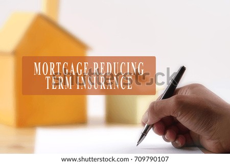 Housing concept agreement/tenancy agreement/property purchase with MORTGAGE REDUCING TERM INSURANCE text. Blurry background.