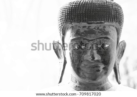 Part of the face of the Buddha made of wood. Black and white picture. This image was blurred 