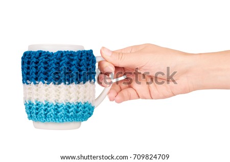 knitted tea cup in hand isolated on white background