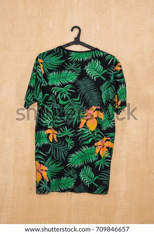 Palm leaves pattern. painted clothes hanging on wooden background