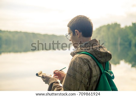 Photo of man in glasses with notebook