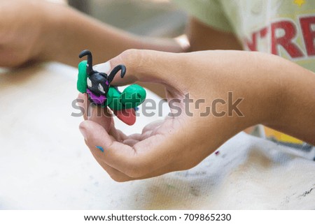 Child playing with colorful clay making animal figures. closeup on hands.
