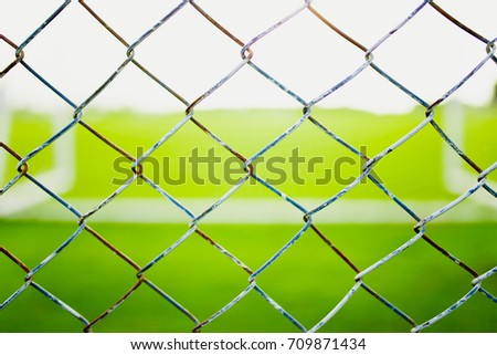Wire mesh steel with green grass background.