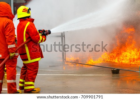 firefighters spray water to fire
