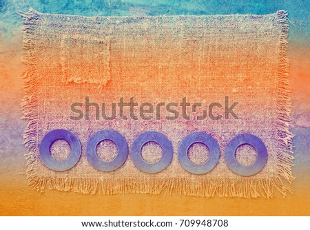 Abstract grunge background. Row of metallic rings washers on sackcloth
