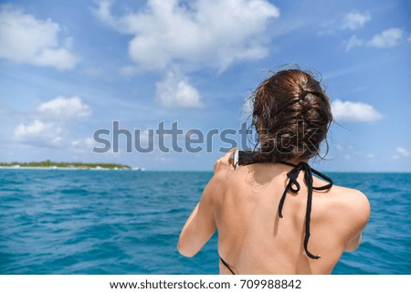 Tourist Woman taking sea photo with her smart phone at Maldives