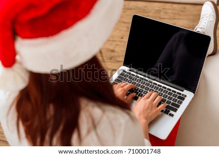 high angle view of woman in santa hat using laptop