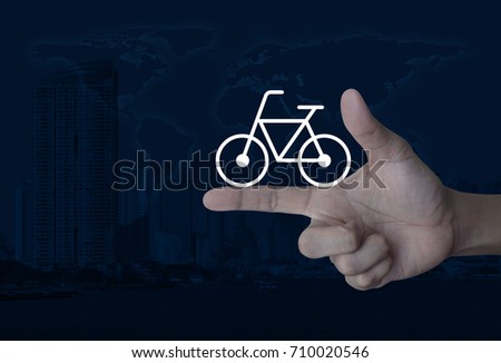 Bicycle flat icon on finger over world map and modern city tower, Healthy lifestyle concept, Elements of this image furnished by NASA