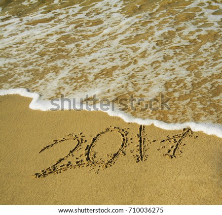 end of 2017  Years with sea blue water. lettering on the beach. digits 2017 on the beach sand - concept of new year,vacation,travel and passing of time