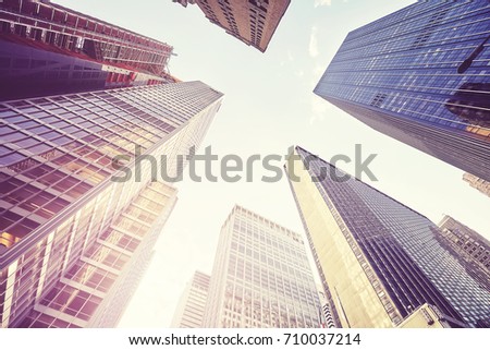 Vintage stylized picture of Manhattan skyscrapers at sunset, looking up perspective, New York City, USA. 