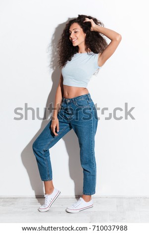 Full length picture of pleased curly woman posing with closed eyes over white background