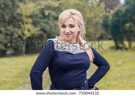 Beautiful girl model in a park, posing for photo camera.