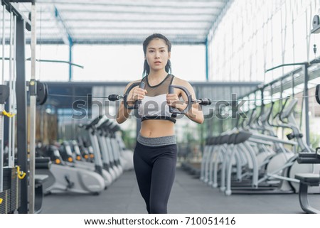 Fitness woman in training showing exercises with exercise-machine in gym, fitness concept, sport concept
