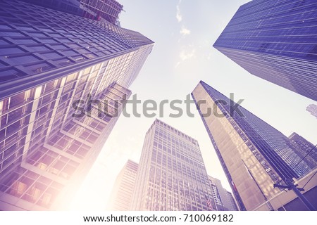 Vintage stylized picture of Manhattan skyscrapers at sunset, looking up perspective, New York City, USA. 