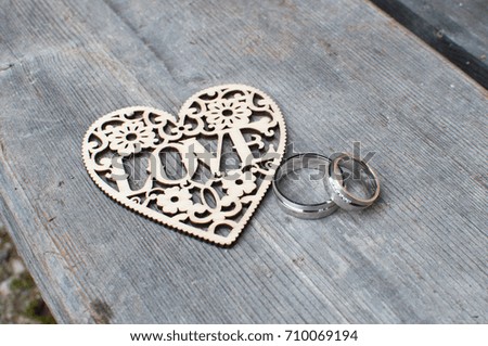 silver wedding rings with wooden hearts love on wooden plank