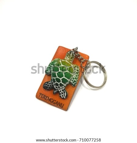 Turtle on a wooden keychain written Terengganu symbolizes states and tourism sites in Malaysia on a white background
