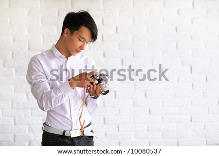 Asian young man uses a camera in the studio
