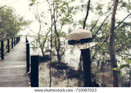 Cream hat with black knot on a wooden bridge, imagine traveling.