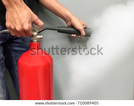 Men hands using red fire extinguisher Royalty-Free Stock Photo #710089405
