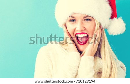 Happy young woman with Santa hat on a blue background