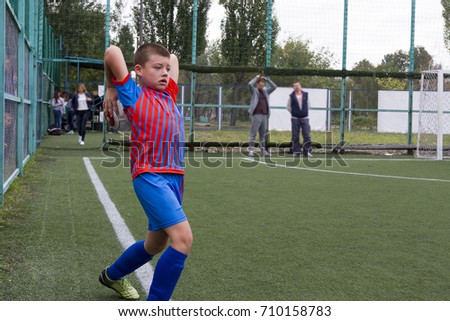 A boy in football uniforms graets in football