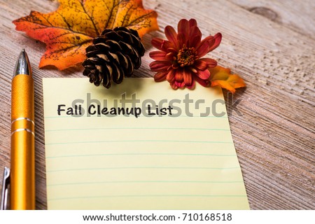 Fall Cleaning List concept on notebook and wooden board
