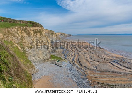Sea cliff and wave cut platform details at the shore line in South Wales-UK Royalty-Free Stock Photo #710174971