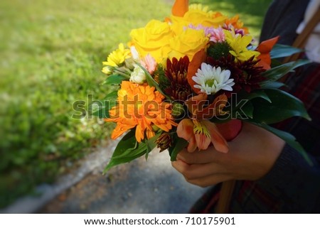 Bright bouquet of different fresh flowers in hands.