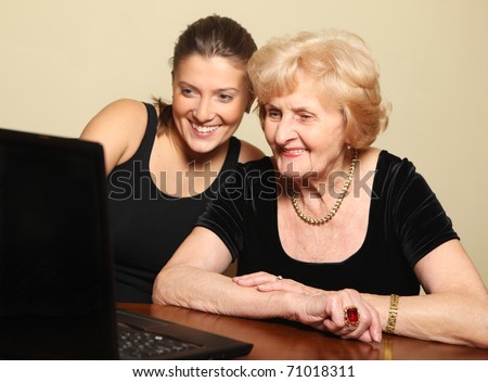 A picture of a senior lady and her granddaughter using computer