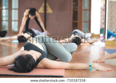 Group Asian women stretching and practices yoga in a class, healthy lifestyle and fitness concept. Selective focus and background blurred. 