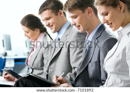 Portrait of four business people reading a text
