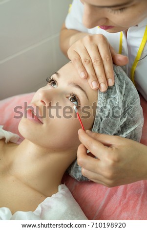 Beautiful young girl at a reception with a beautician doing a face cleaning