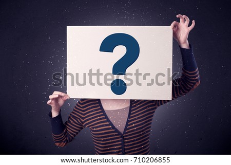 Young casual woman hiding behind a question mark drawn on paper 