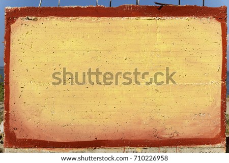 Signboard - yellow painted concrete wall with red frame around; copy space, blank.