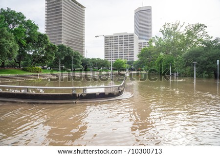 High and fast water rising in Bayou River from Montrose boulevard with near town Houston in background, cloud sky. Heavy rains from Tropical Hurricane storm caused many flood in greater Houston areas