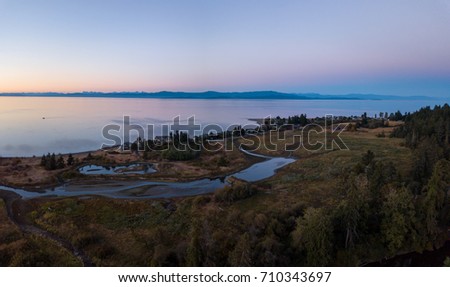 Aerial panoramic landscape view of the beautiful scene of Strait of Georgia. Picture taken near Qualicum Beach, Vancouver Island, British Columbia, Canada, during summer sunset.
