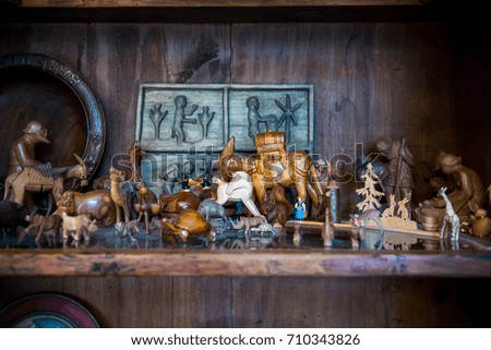 Different kind of old vintage wooden figures placed on the wooden closet.